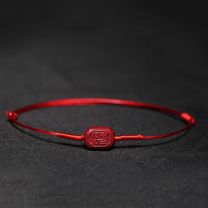 Rotes Armband Zinnober Koi Fisch Liebe Segen auf dunklem Hintergrund