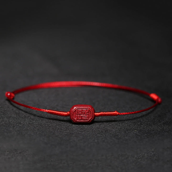 Rotes Armband Zinnober Koi Fisch Liebe Segen auf dunklem Hintergrund
