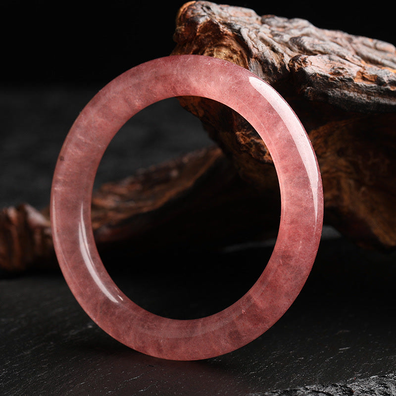 Erdbeerquarz Armband poliert Naturstein rosa Holz Hintergrund elegant