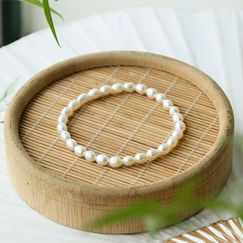 Armband Perle – Heilung weißes Perlenarmband auf Bambuschale Nahaufnahme