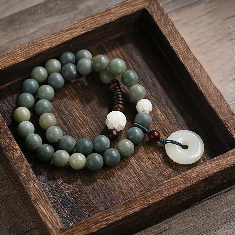 Bodhi Jade Lotus Armband mit grünen Steinen und weißem Anhänger.