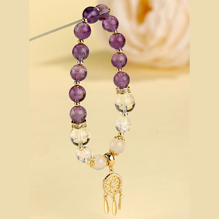 Amethyst Erdbeerquarz Armband mit goldenem Anhänger elegant präsentiert.