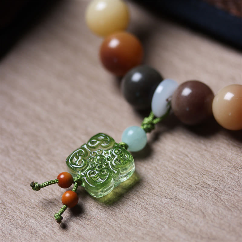 Bodhi Armband mit Natursteinen und grünem Jade Anhänger auf Leinen.