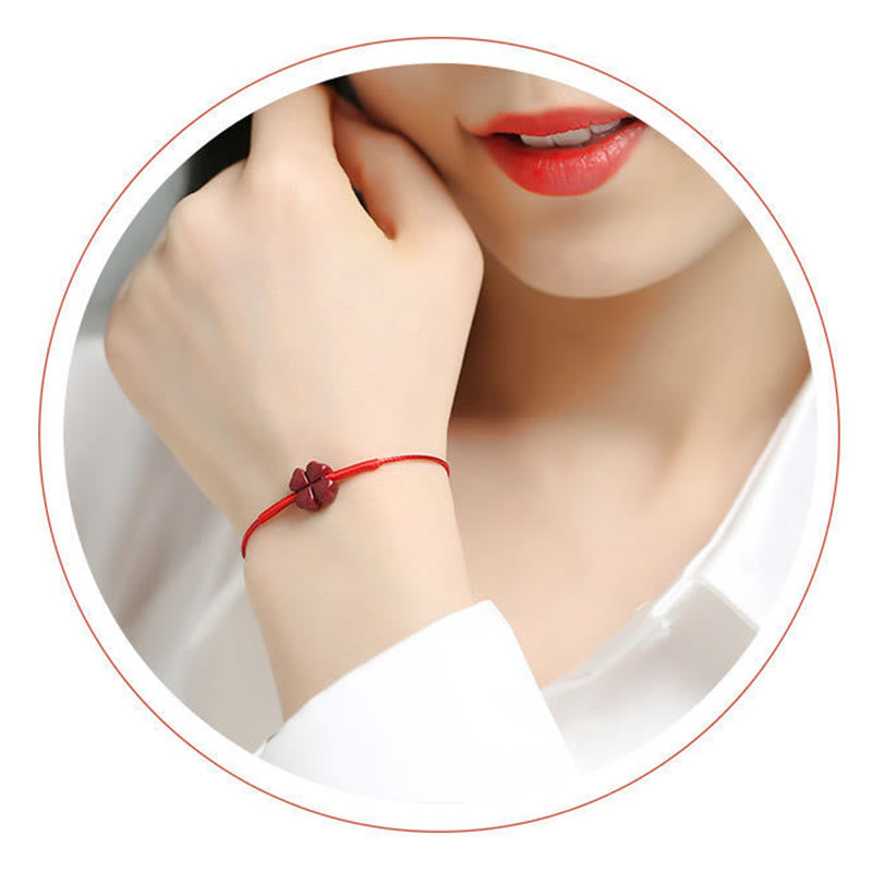 Rotes Armband mit Koi Fisch Charm am Handgelenk getragen Nahaufnahme