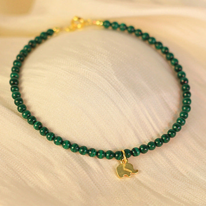 Grünes Malachit Armband mit goldenem Elefant Anhänger am Handgelenk