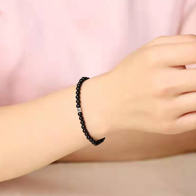Schwarzes Obsidian Armband am Handgelenk getragen, elastisch mit Katze-Anhänger