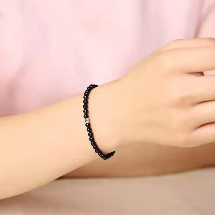 Schwarzes Obsidian Armband am Handgelenk getragen, elastisch mit Katze-Anhänger