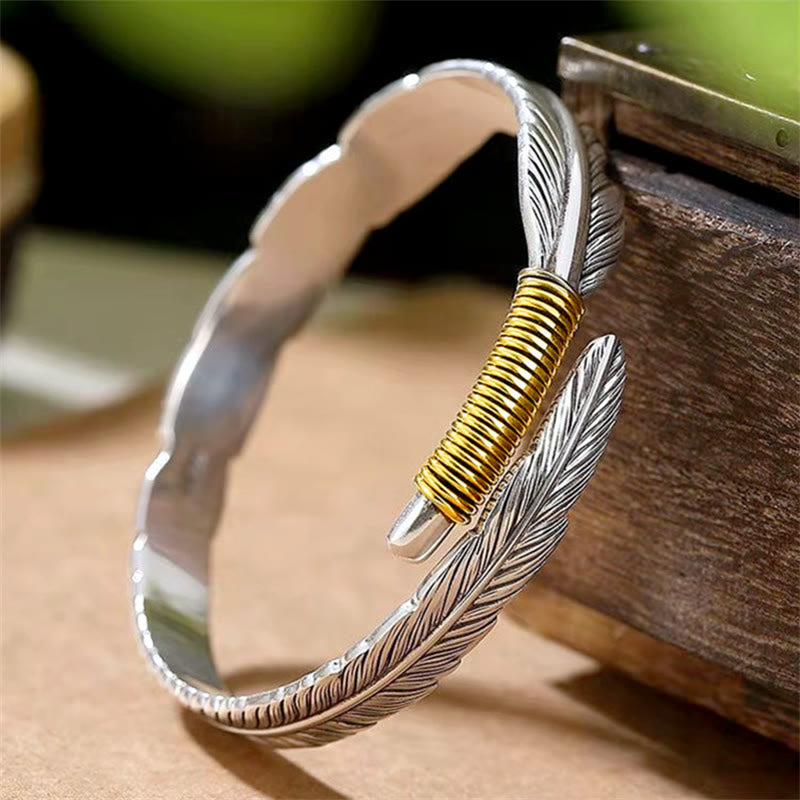 Silbernes Feather Armband mit goldener Wicklung elegant getragen.