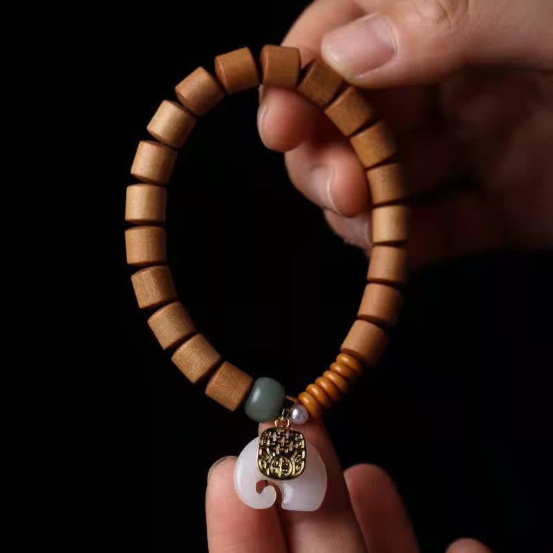 Armband Sandelholz Jade Elefant am Handgelenk mit Schutzanhänger getragen.