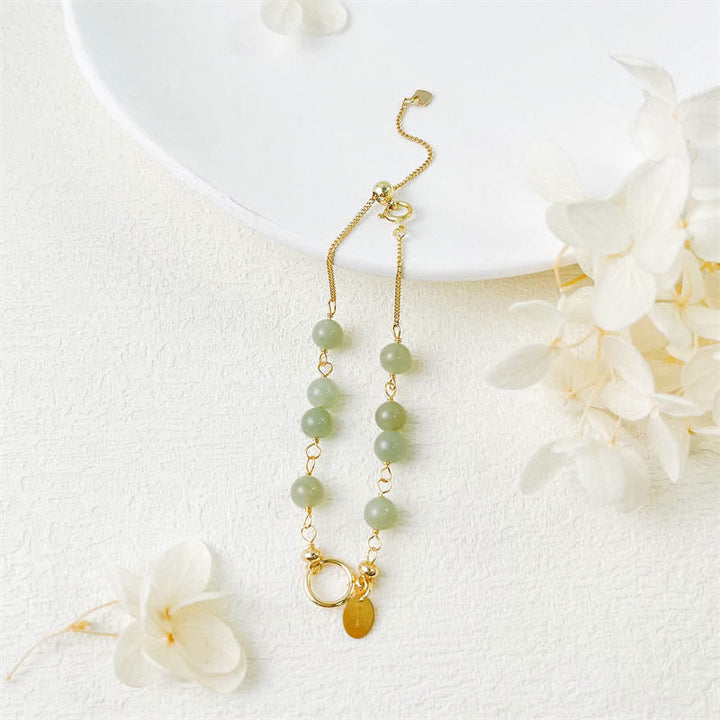 Jade Armband mit grünen Steinen und goldenen Kettendetails elegant.