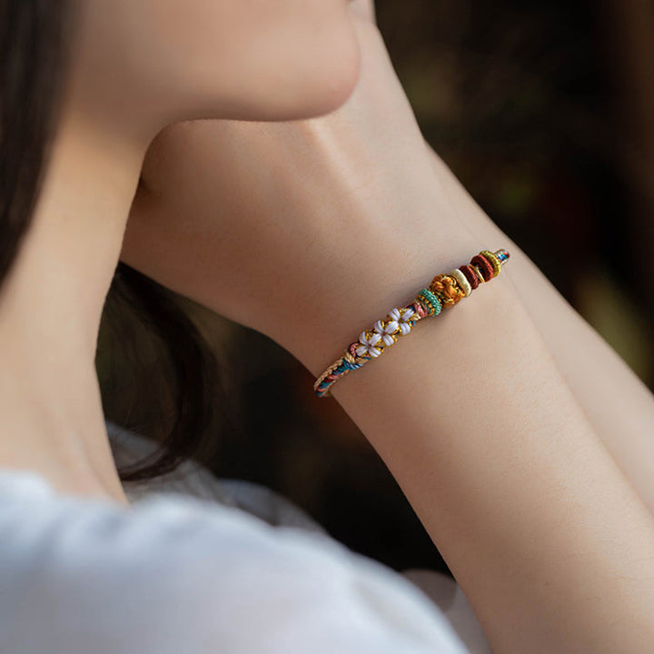 Armband Pfirsichblüte mit bunten Perlen am Handgelenk getragen elegant