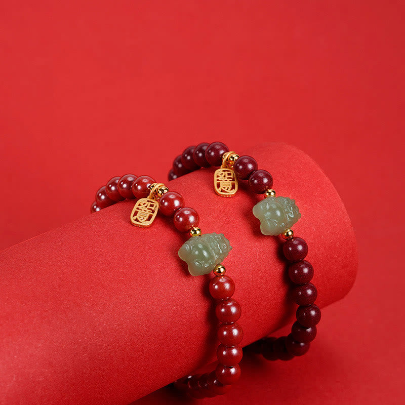 Rotes Armband mit Granaten und Jade Glückszeichen elegant präsentiert.
