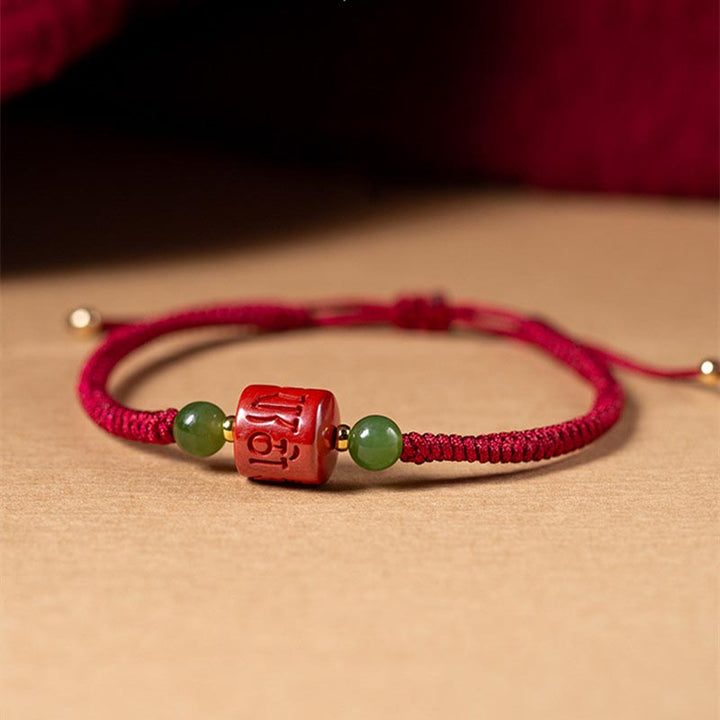 Rotes Armband mit Om Symbol und grünen Jadekugeln elegantly styled.