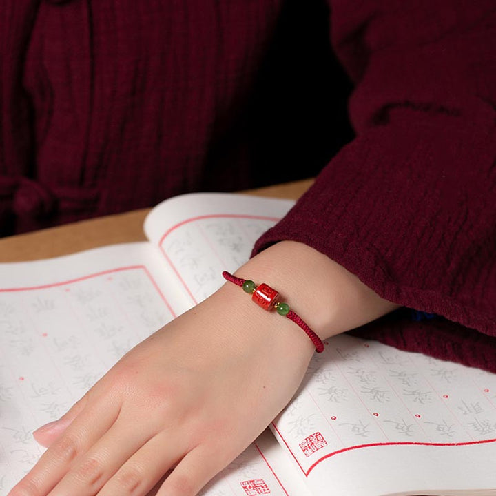 Rotes Armband Zinnober Om Mani Padme Hum am Handgelenk getragen elegant