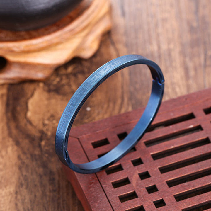 Blaues Titanstahl Armband Segen Armreif auf Holzoberfläche elegant.