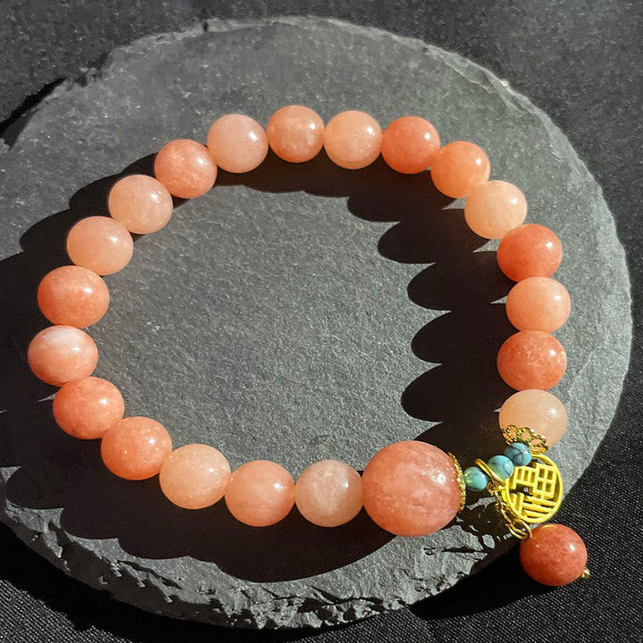 Orangener Stein Armband mit goldener Fu-Zeichen Charm Perlen.