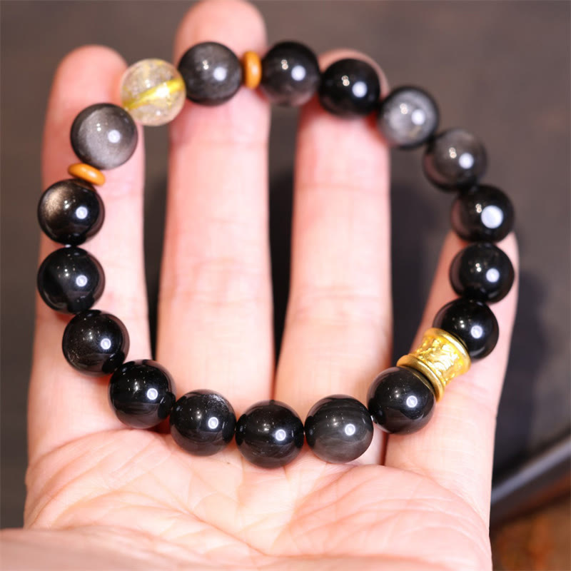 Schwarzes Obsidian Armband mit goldenen Perlen am Handgelenk getragen