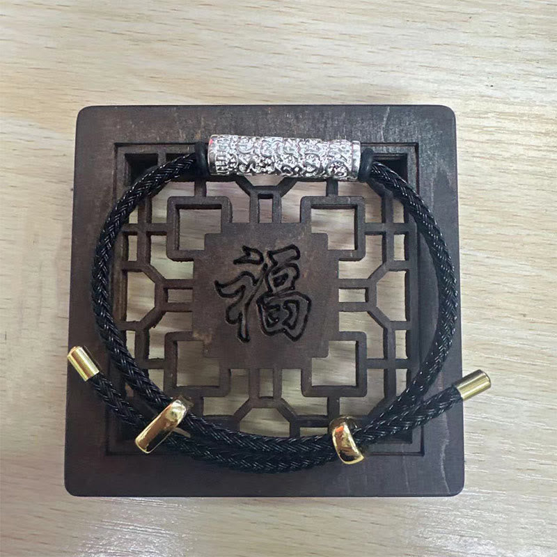 Schwarzes Armband mit Schutzplakette Stärke und chinesischen Zeichen.