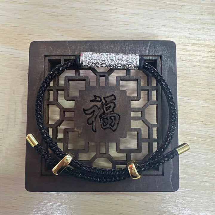 Schwarzes Armband mit Schutzplakette Stärke und chinesischen Zeichen.