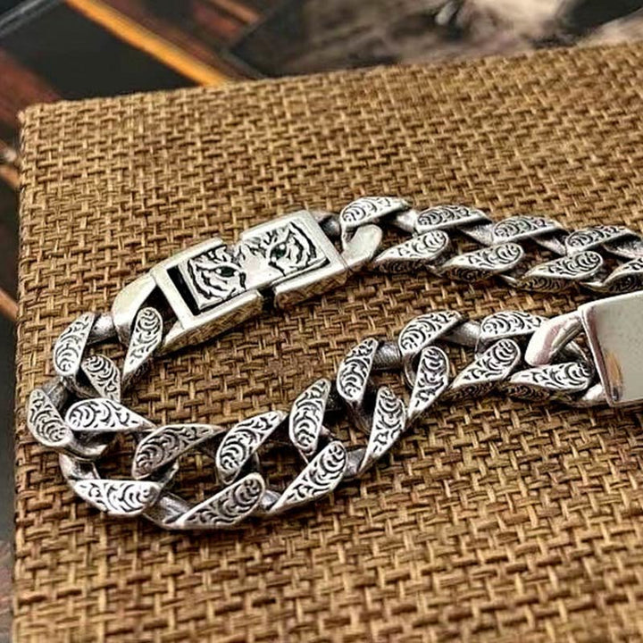 Silbernes Armband mit Tigerauge Tang Glück Muster auf Textil.