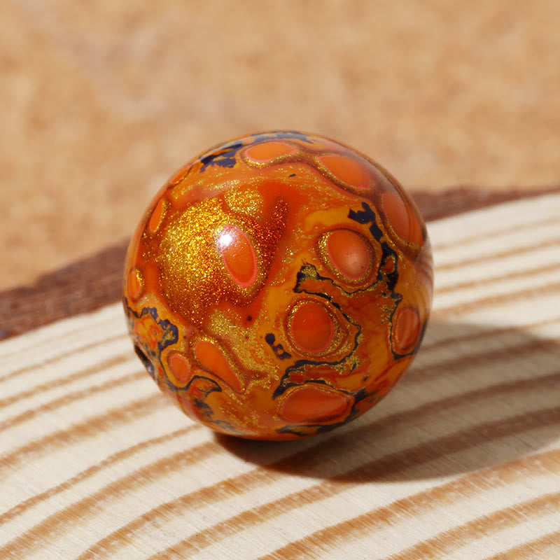 Orangefarbenes Lacquer-Perlen Armband mit goldenem Glitzer und schwarzen Details