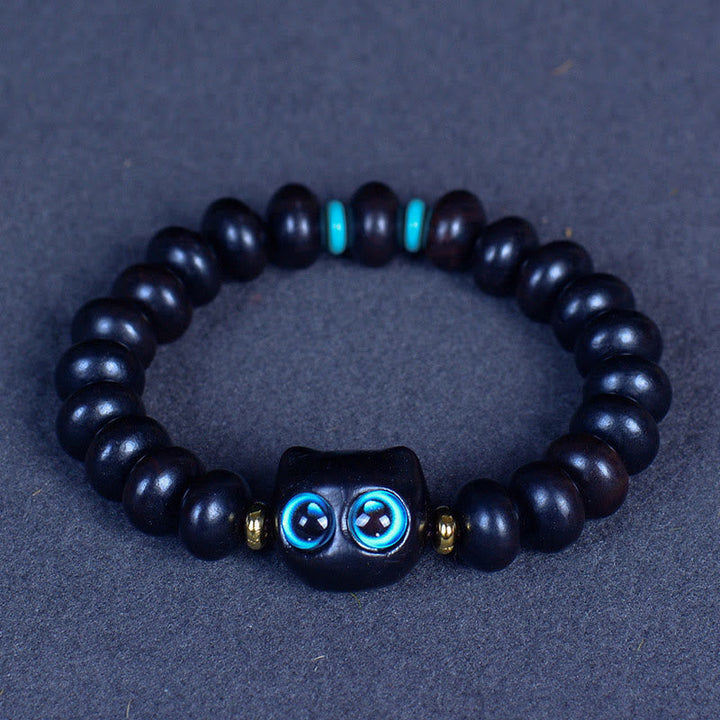 Armband Ebenholz Katze mit blauen Augen und Goldperlen elastisch.