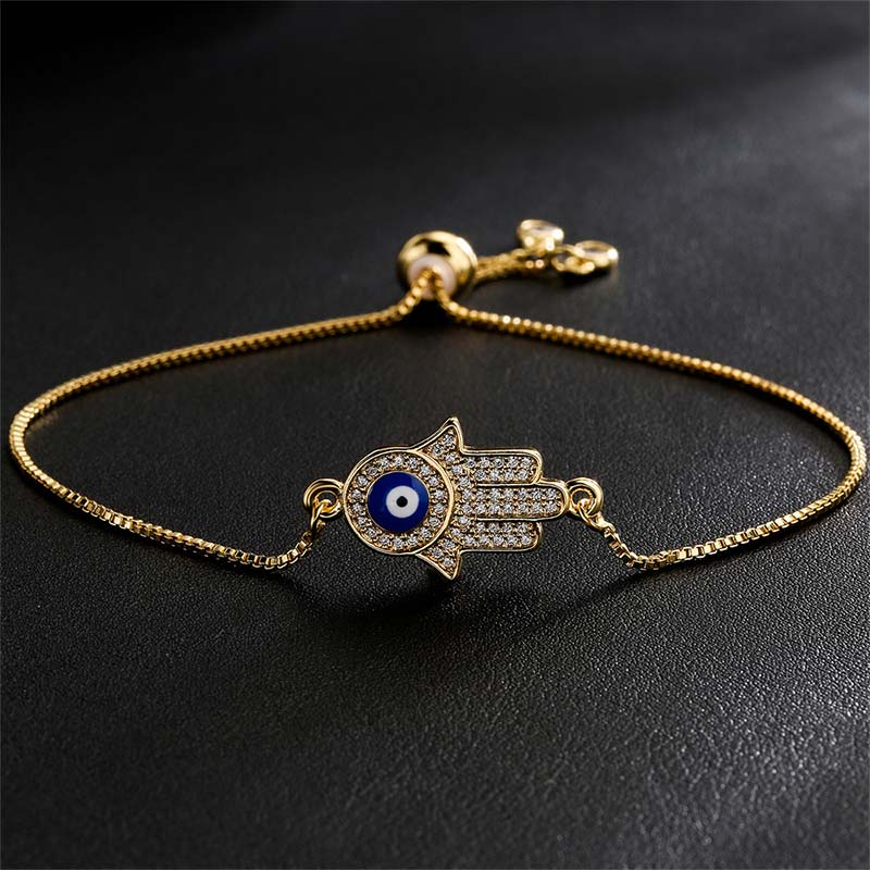 Goldenes Armband Böses Auge – Schutz & Mut mit blauen Steinen Flatlayaufnahme