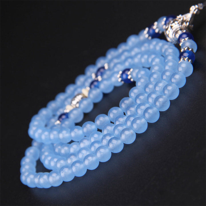 Blaues Kristall Mala Armband mit 108 Perlen elegant drapiert schwarzem Hintergrund