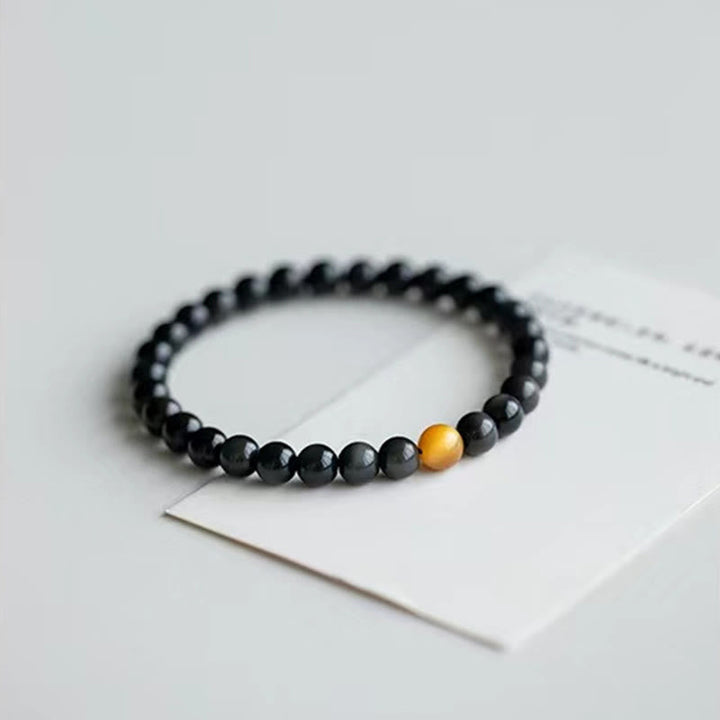 Schwarzes Obsidian Armband mit goldenem Tigerauge Stein elegant.