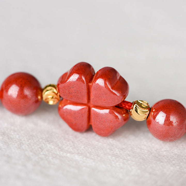 Armband Zinnober Kleeblatt rote Perlen Glücksbringer Flachaufnahme Details