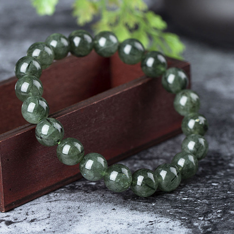 Grünes Kristall Armband Wohlstand & Segen auf Holzbox Nahaufnahme