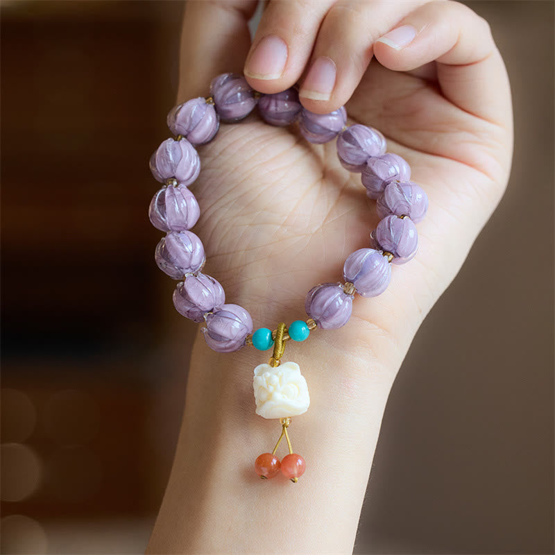 Armband Fluorit Lotus lila Perlen Türkis Anhänger Handgelenk getragen