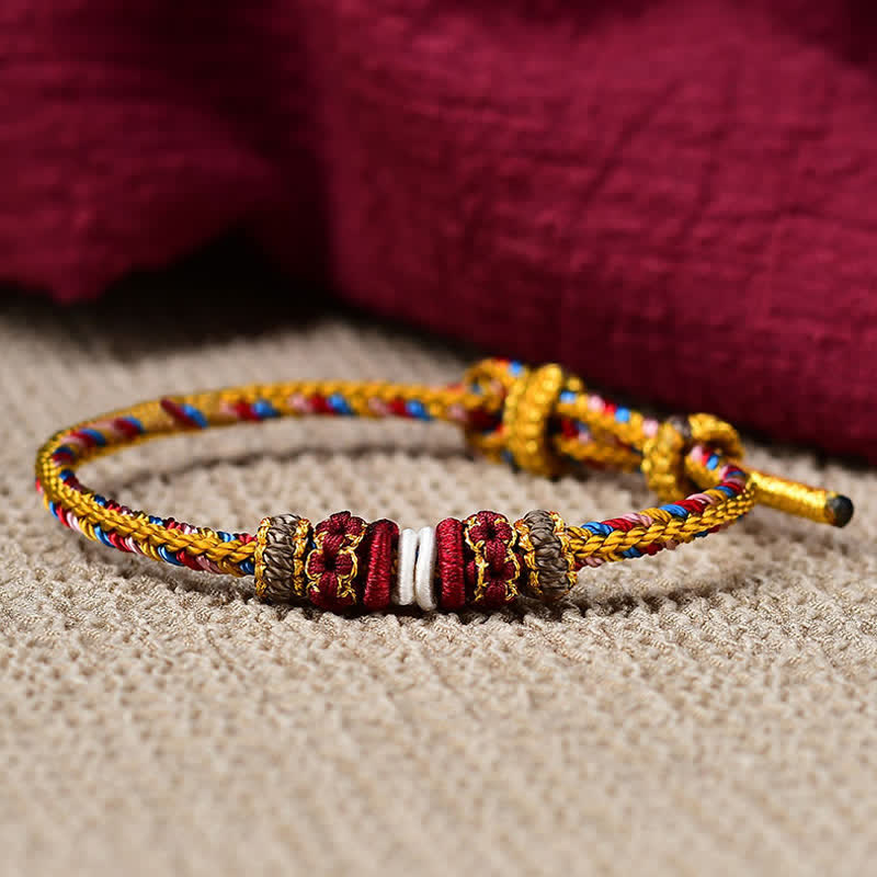 Geflochtenes rotes Schnur Armband mit goldenen Perlen Flachaufnahme Karma Schutz