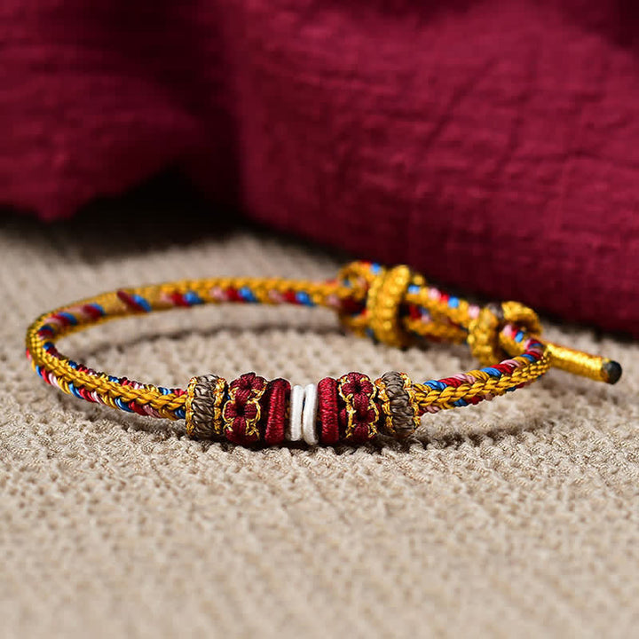 Geflochtenes rotes Schnur Armband mit goldenen Perlen Flachaufnahme Karma Schutz