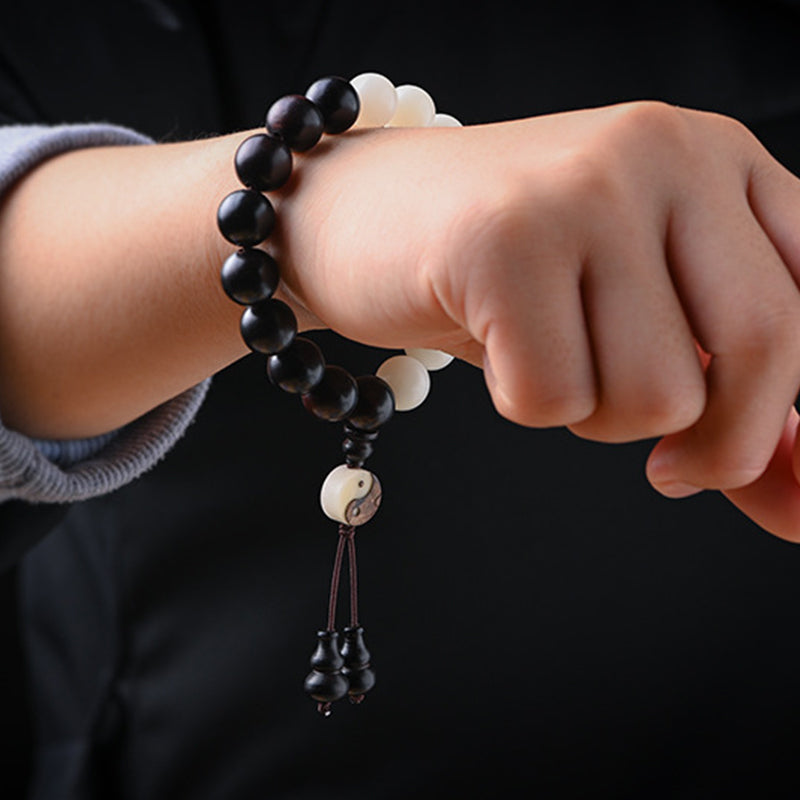 Armband Ebenholz – Schutz mit Yin Yang Anhänger am Handgelenk getragen.