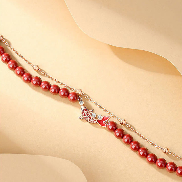 Rotes Perlen Armband mit silbernem Koi Fisch Anhänger elegant präsentiert