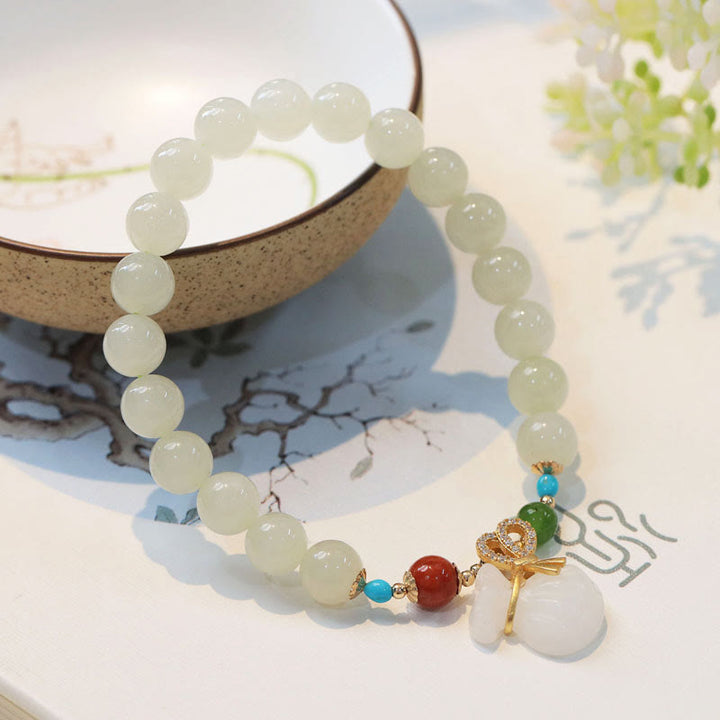 Armband Weiße Jade – Segen mit goldenen Charms elegant gestylt