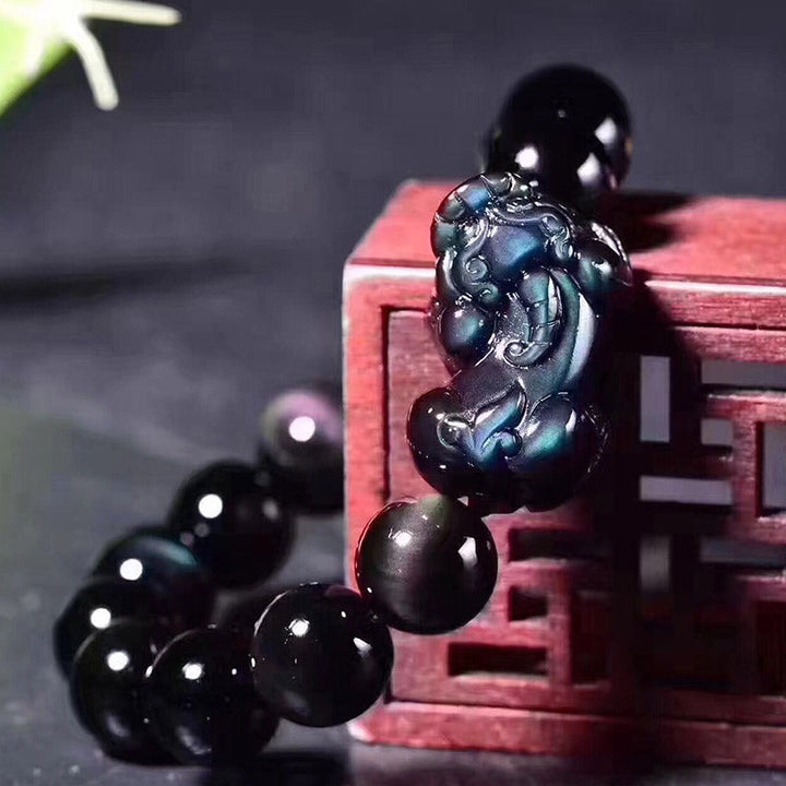 Schwarzes Obsidian Pixiu Armband mit Perlen auf rotem Holzkasten Detail