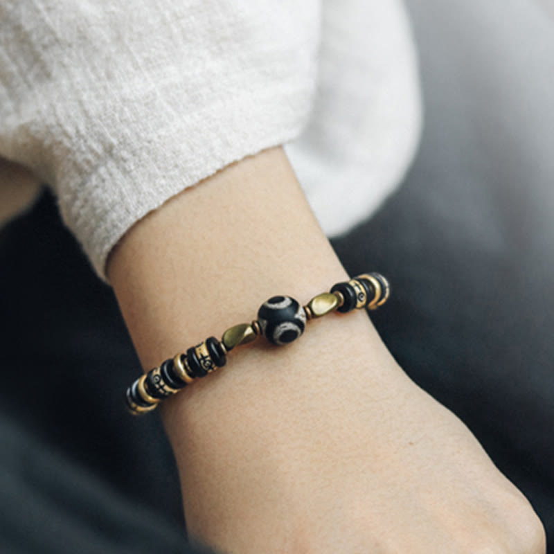 Armband Ebenholz mit goldenen Perlen und schwarzem Stein Handgelenk.