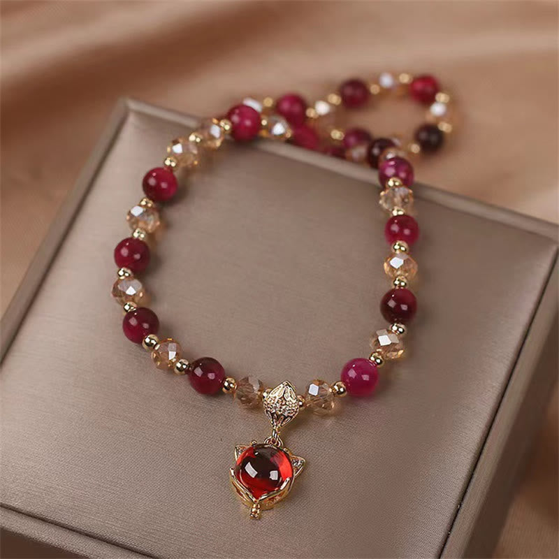 Armband Tigerauge Fuchs mit roten Steinen und goldenem Anhänger elegant.