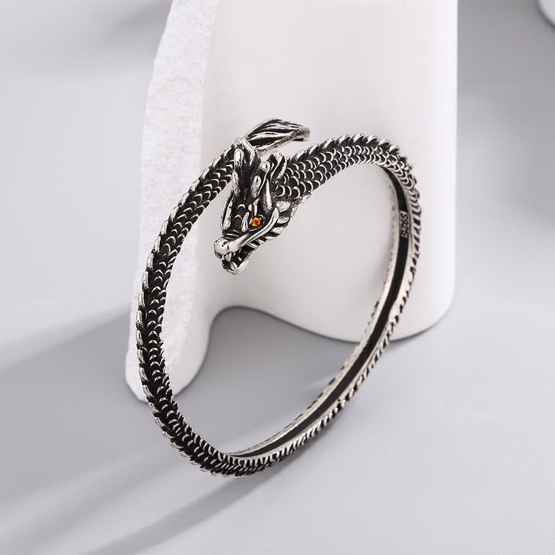 Silbernes Drachen Armband mit Bernstein Auge auf weißem Hintergrund.