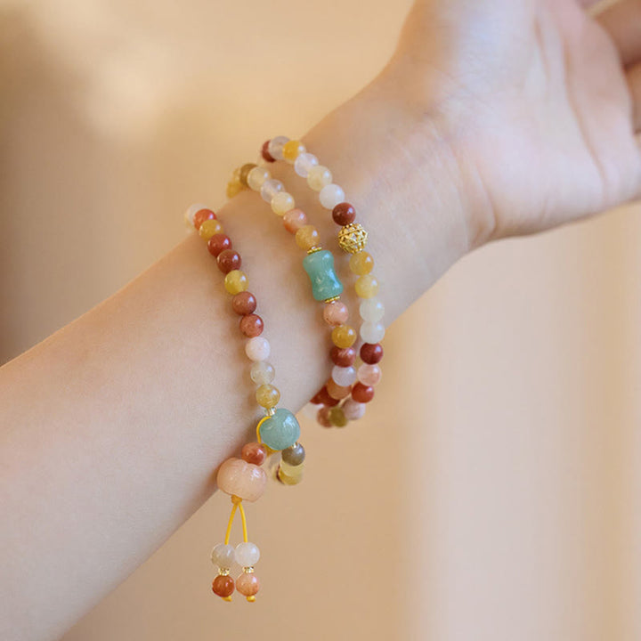 Jade Armband Gold mit bunten Steinen am Handgelenk getragen elegant