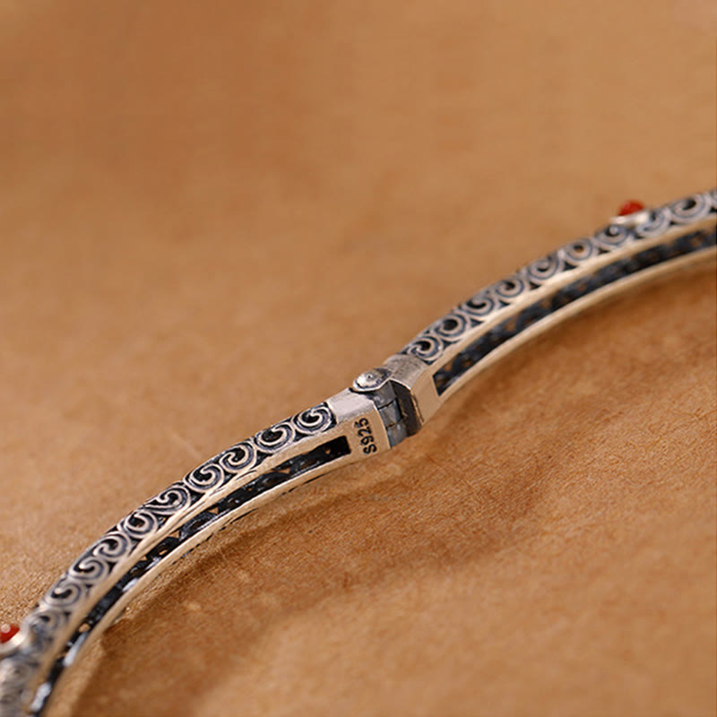 Silbernes Armband mit Ornamenten auf braunem Hintergrund Nahaufnahme