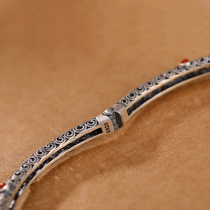 Silbernes Armband mit Ornamenten auf braunem Hintergrund Nahaufnahme