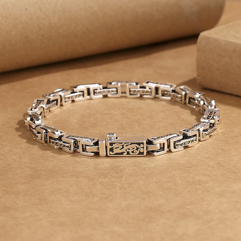 Silbernes Armband Kupfer Om Mani Padme Hum auf Papierhintergrund Flatlay