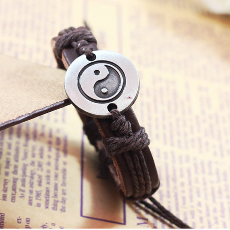 Armband Yin Yang – Harmonie mit braunem Lederband auf Buch