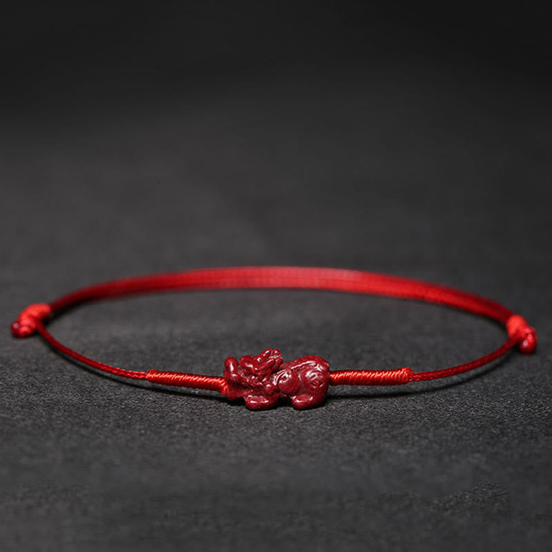 Rotes Armband Zinnober Koi Fisch Liebe Segen auf dunklem Hintergrund.