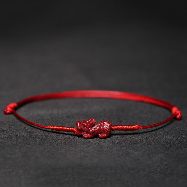 Rotes Armband Zinnober Koi Fisch Liebe Segen auf dunklem Hintergrund.