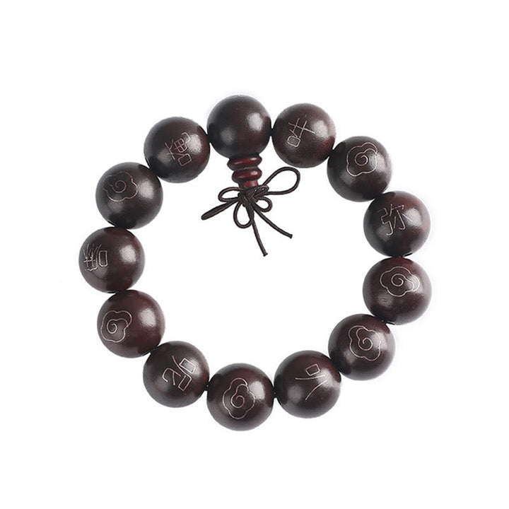 Dunkelbraunes Sandelholz Armband mit eingravierten Symbolen und Kordelverschluss.
