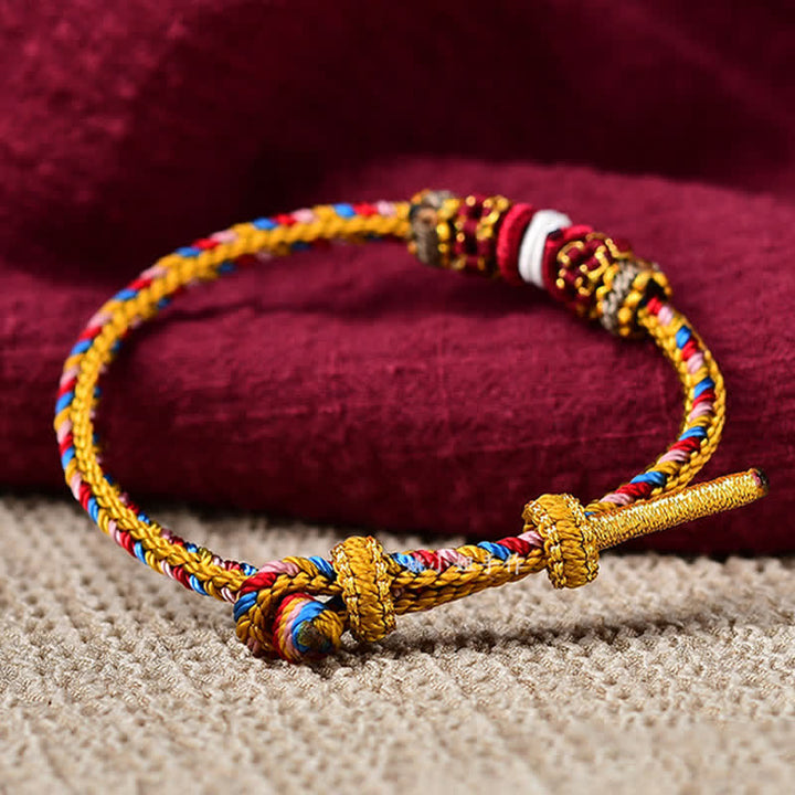 Geflochtenes rotes Schnur Karma Armband mit goldenen Elementen Detailaufnahme